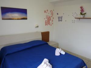 Un dormitorio con una cama azul con zapatos. en Residence Costablu en Rímini