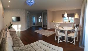 a living room and kitchen with a table and chairs at Apartament Smilčių skg in Palanga