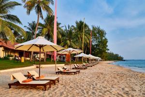 een rij stoelen en parasols op een strand bij Chen Sea Resort & Spa Phu Quoc in Phu Quoc