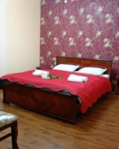 a bedroom with a bed with red sheets and white pillows at Carat Hotel in Tashkent