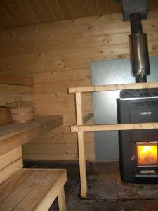 a log cabin with a stove and a bench at Söderhagen Camping och Gästhem in Eckerö +51 photos