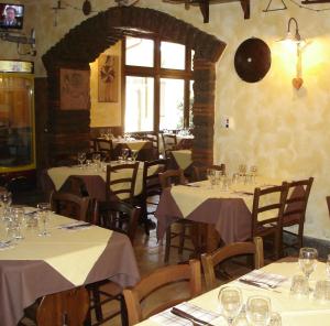 un restaurante con mesas y sillas con manteles blancos en Agriturismo Casale Di Gricciano, en Cerveteri