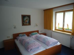 ein Schlafzimmer mit einem Bett mit Kissen darauf in der Unterkunft Pension Susanne in Sankt Anton am Arlberg