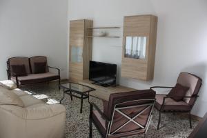 a living room with a couch and a tv at Villetta Angela in Torre San Giovanni Ugento +6 photos