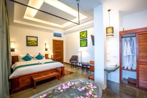 a hotel room with a bed and a desk at The Tito Suite Residence in Siem Reap