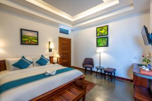 a bedroom with a large bed and a desk at The Tito Suite Residence in Siem Reap
