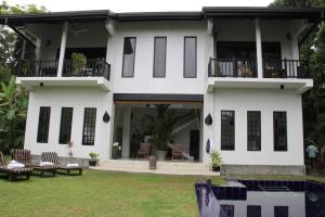 a white house with a balcony and a yard at Madampe House 3 bedroom villa with pool for#7 in Ambalangoda
