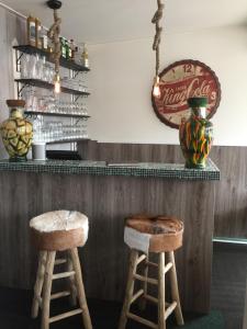 a bar with two stools in front of a counter at Pension Even Buiten in Burgh Haamstede