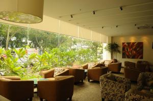 a waiting room with chairs and tables and a large window at The Jerai Hotel Alor Star in Alor Setar