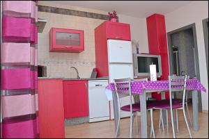 コニル・デ・ラ・フロンテーラにあるApartamento cerca Playa Batelesのキッチン(赤いキャビネット、紫色の椅子とテーブル付)