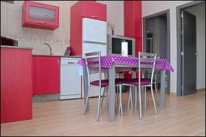 コニル・デ・ラ・フロンテーラにあるApartamento cerca Playa Batelesのキッチン(テーブル、紫色の椅子、赤いキャビネット付)