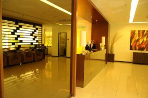 two people standing at a counter in a lobby at The Jerai Hotel Alor Star in Alor Setar