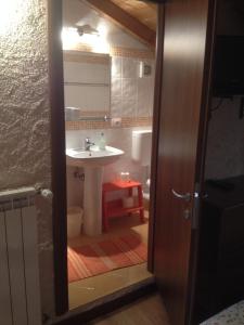 bagno con lavandino, servizi igienici e specchio di La Tana del Ghiro a Porto Valtravaglia