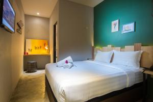1 dormitorio con 1 cama blanca grande y pared verde en Finess Basic Hotel, en Melaka