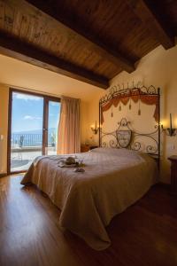 a bedroom with a large bed with a large window at Borgo Medievale in Castelmola
