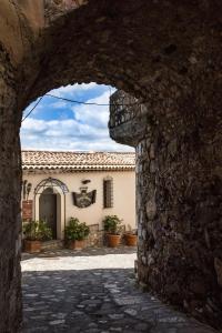 an archway in a stone wall with a building at Borgo Medievale in Castelmola