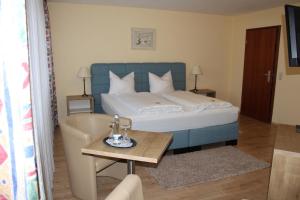 1 dormitorio con 1 cama con mesa y silla en Hotel Restaurant Weisbrod, en Freinsheim