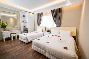 Postel nebo postele na pokoji v ubytování Little Hanoi Deluxe Hotel