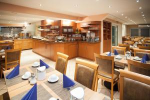 un ristorante con tavoli e sedie e una cucina di Centro Hotel Mondial a Monaco