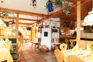 un restaurante con mesas, sillas y techos de madera en Alpenhof Reuterwanne en Wertach