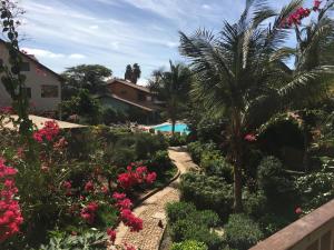 a garden with pink flowers and a swimming pool at Porto Antigo 2 in Santa Maria