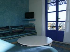 a living room with a white table and a couch at Un Thé Au Bout Du Monde in Mirleft