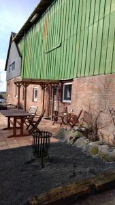 a building with a green roof and a picnic table at Fewo Bendig in Neuendorf-Sachsenbande