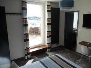a bedroom with a window with a view of the water at Hôtel des Rochers in Perros-Guirec