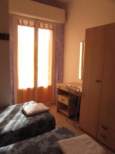 una camera con letto, scrivania e finestra di Hotel Villa Elia a Rimini