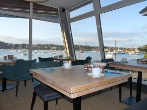 a restaurant with tables and chairs with a view of the water at Hôtel des Rochers in Perros-Guirec