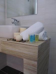 a bathroom counter with candles and towels on it at Hippocampus Hotel in Kamari