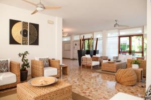 un soggiorno con sedie e tavoli in vimini di Hotel Horizonte a Bibione