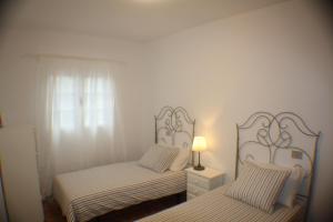 プンタ・ムヘーレスにあるApartamento Las Salinasのベッドルーム1室(ベッド2台、ナイトスタンドのランプ付)