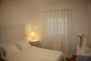 プンタ・ムヘーレスにあるApartamento Las Salinasの白いベッドルーム(ベッド1台、窓付)