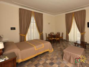 une chambre d'hôtel avec un lit et une table dans l'établissement Dimora conte di Ruvo, à Naples