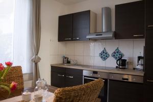 a kitchen with black cabinets and a table and a counter top at Ferienwohnung Ohligs in Solingen