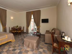 une chambre d'hôtel avec un lit, un canapé et une table dans l'établissement Dimora conte di Ruvo, à Naples