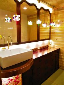 ein Bad mit einem Waschbecken und einem Spiegel in der Unterkunft Dyeing and Hostel Nakashimaya - Female Only in Kumamoto