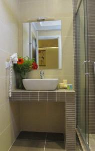 a bathroom with a sink and a mirror at Hippocampus Hotel in Kamari