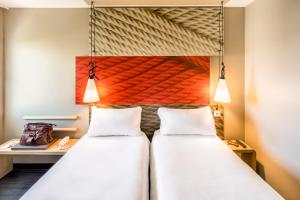 a bedroom with a bed and two lamps at Hotel ibis Faro Algarve in Faro