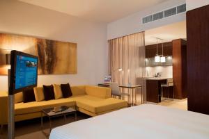 a hotel room with a couch and a kitchen at Centro Capital Centre By Rotana in Abu Dhabi