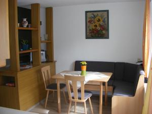 uma sala de estar com uma mesa e um sofá em Ferienwohnung Huber em Dornbirn