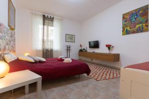 1 dormitorio con cama roja y TV en Apartment Silvia en Turín