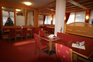 a dining room with red chairs and tables in a restaurant at Garni Lago Nembia in San Lorenzo in Banale