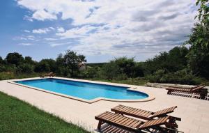 a swimming pool with two deckchairs and two loungers at Villa Dusan 1212 in Svetvinčenat