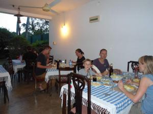 a group of people sitting at a table in a restaurant at Little Paradise Tourist Guest House and Holiday Home in Anuradhapura