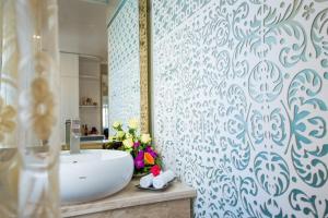 La salle de bains est pourvue d'un lavabo blanc et d'un miroir. dans l'établissement Little Hanoi Deluxe Hotel, à Hanoï