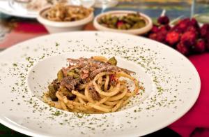 a plate of pasta with meat on a table at Residenza d'Epoca Borgodifiume in Fiumefreddo Bruzio