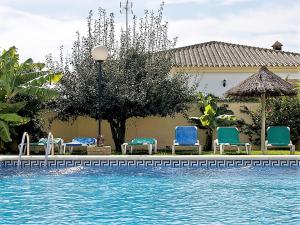 uma piscina com cadeiras e guarda-sóis ao lado de uma casa em Casas Marin em Conil de la Frontera