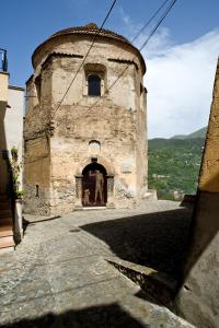 an old stone building with a doorway and a window at Residenza d'Epoca Borgodifiume in Fiumefreddo Bruzio